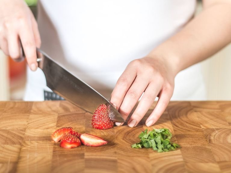 Meanwhile, slice mint into fine strips. Wash strawberries, remove the stalks and halve.