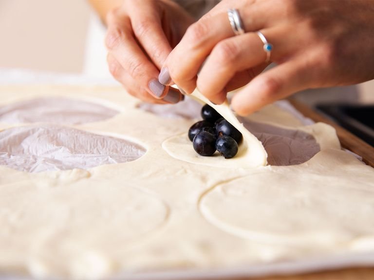 Preheat oven to 210°C/410°F. Cut circles out of thawed puff pastry with a round cookie cutter. Lay fresh blueberries onto each circle and fold in half. Press the edges together with a fork to seal, and poke once or twice on top to make small holes for steam to escape. Transfer to a baking sheet and bake for approx. 10 min. or until golden brown.