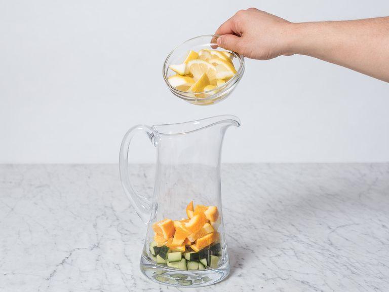 Dice oranges, lemons, and cucumber. Transfer to a large bowl or pitcher.