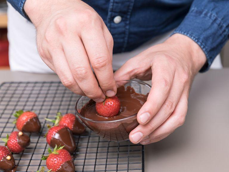 Für die schokolierten Erdbeeren die restliche Schokolade hacken und über dem Wasserbad schmelzen. Restlichen Erdbeeren in Schokolade tunken (die großen komplett reintunken, die kleinen Erdbeeren nur zur Hälfte). Ca. 1 Min. stehen lassen und dann die großen Erdbeeren mit Goldkügelchen (oder anderen Zuckerstreuseln) verzieren. Erst einmal erkalten lassen und dann bis zur Verwendung in den Kühlschrank stellen.