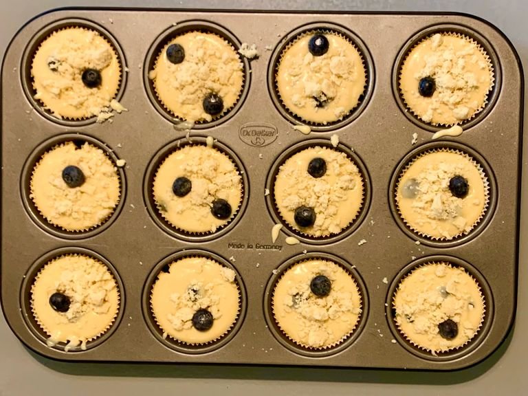 Set the muffin liner in the muffin tin and pour the muffin mixture in there place and on the top sprinkle the crust mixture. The very last step is to pop it in the the preheat oven (200 c) for 13-14 min.