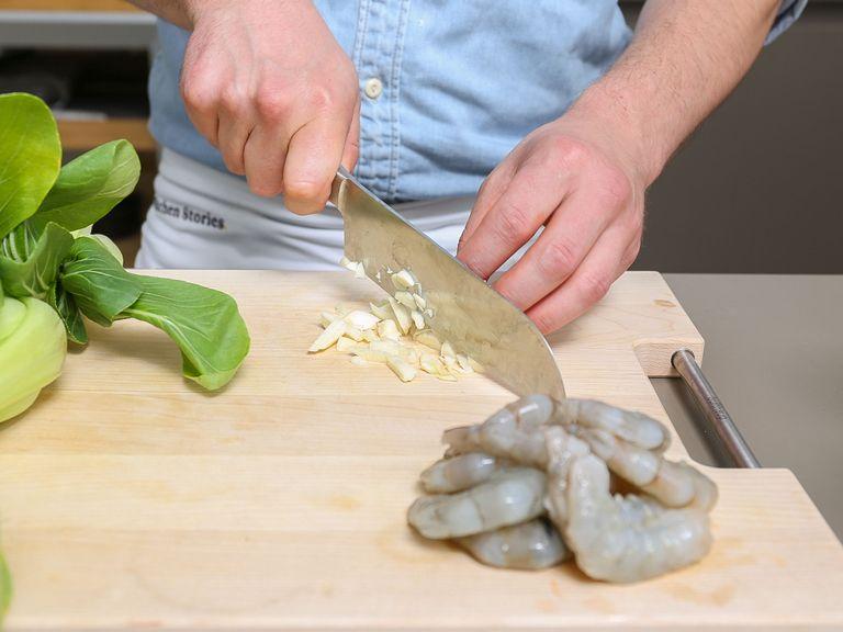 Peel and chop garlic. Trim ends of baby bok choy, then halve. Wash shrimp and remove peel.