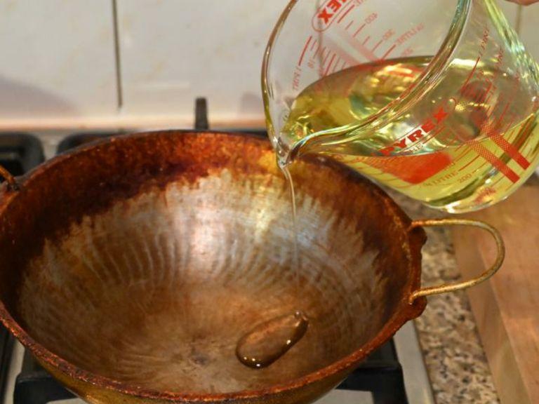 Heat oil in a deep fryer or a deep frying wok. Drop a few breadcrumbs to see if the oil is heated; if the oil sizzles then the oil is heated.