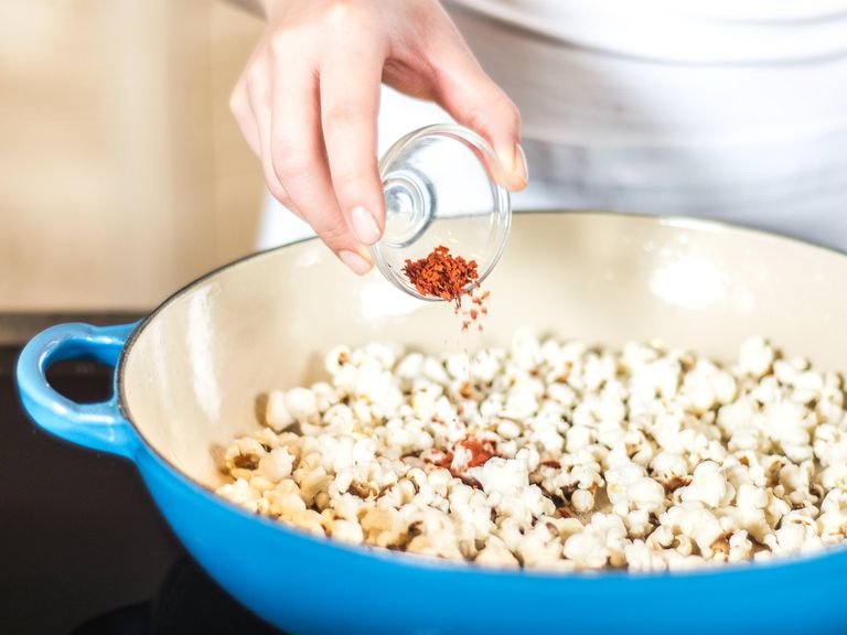Für das pikante Popcorn Pflanzenöl erhitzen, Popcornmais hinzugeben und bei geschlossenem Deckel und mittlerer Hitze die Maiskörner aufpoppen lassen. Das fertige Popcorn nach Belieben mit Chilipulver und Salz würzen.