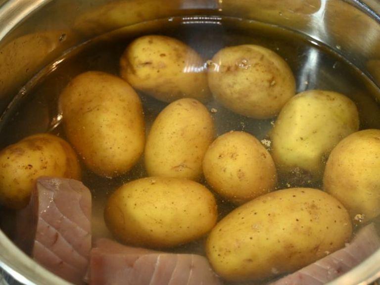 In a saucepan filled with water, boil the potatoes and tuna fish. (The water in the pan should cover the potatoes and fish).