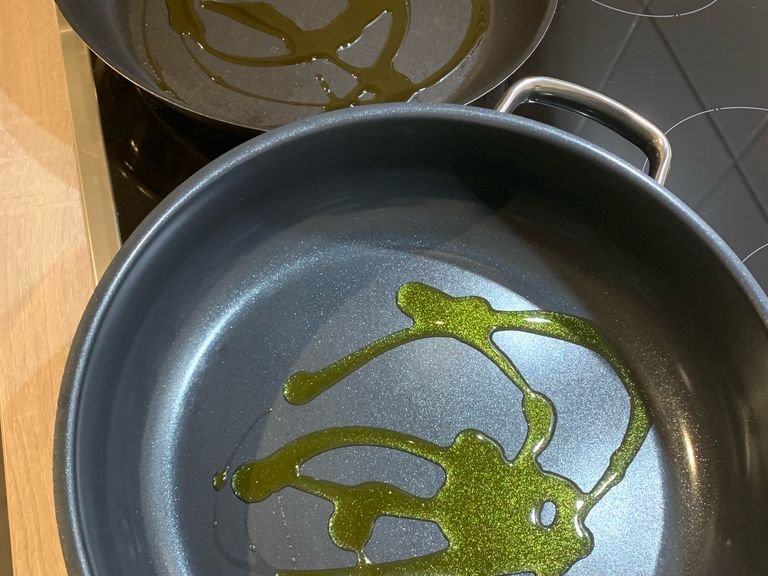 Zu Beginn stellt man sich bereits zwei gut beschichtete Pfannen bereit und gibt Olivenöl rein. Den Herd auf mittlere Hitze einstellen. Den Ofen auf 180 Grad bei Umluft (Ober-Unterhitze ist ebenfalls möglich) vorheizen.