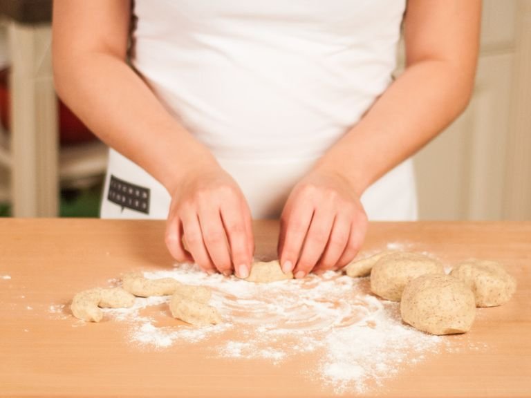 Take small portions of the dough (approx. 1 tablespoon) and form cookies by rolling dough into the shape of a half moon.