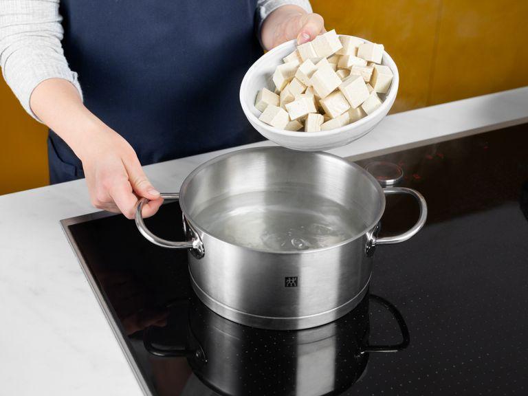 Bring a pot of salted water to a boil. Add tofu and let soak for approx. 10 min., then drain and set aside. Mix starch and water in a small bowl. Add sichuan peppercorns and dried chili to a frying pan over medium heat and toast until fragrant, then transfer to a mortar and pestle and grind.