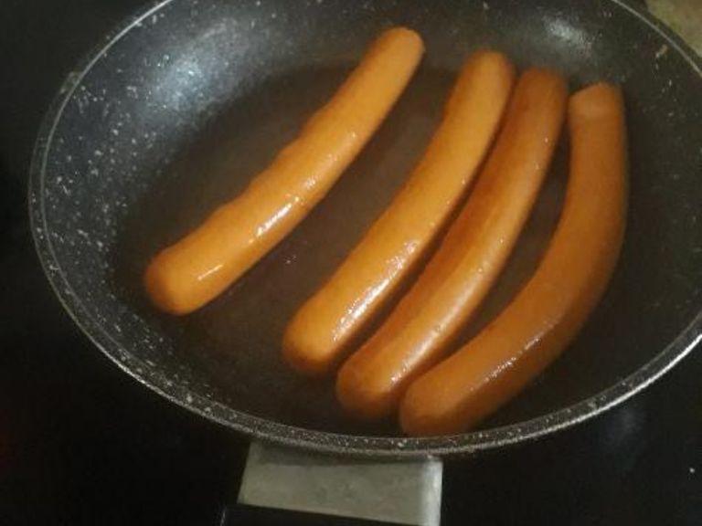 put 3 or 4 sausages in and turn the volume lower. wait till the sausages have a darker colour and heat coming, then turn them around and wait 4 min. once you have waited get a fork and place them on a plate