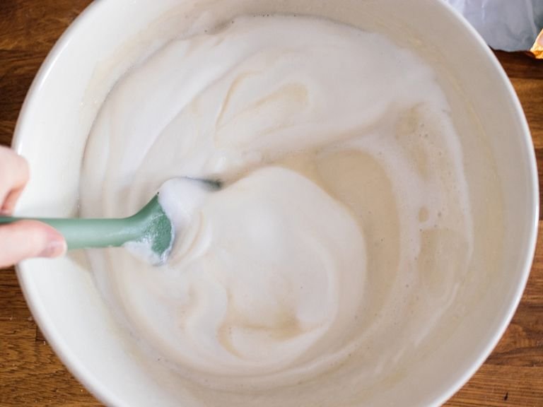In another bowl, mix flour, sugar, and baking powder together. Add plant-based milk and melted margarine and stir until a smooth batter forms. Stir in sparkling water, then gently fold in the beaten aquafaba.