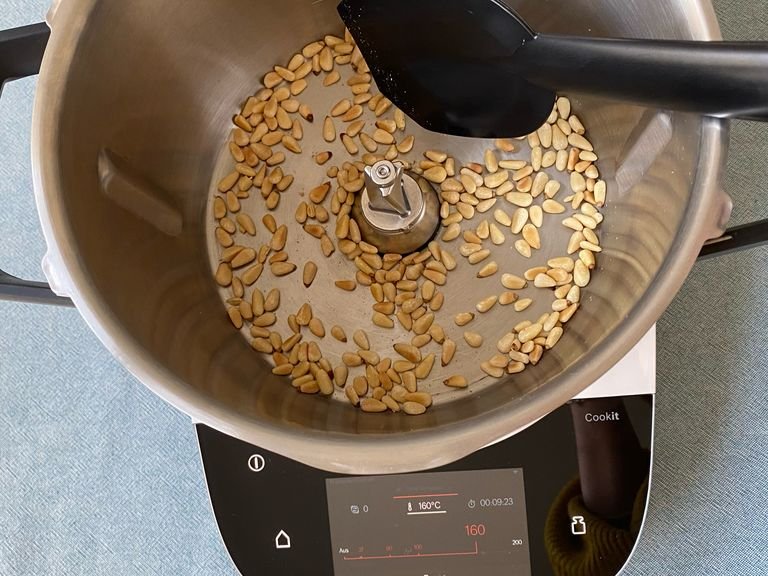 Die Pinienkerne in den Cookit geben und ohne Deckel rösten (ohne Werkzeug | 160°C | 10 Minuten), dabei zwischendurch mit dem Cookit Küchenspatel umrühren. Die goldbraunen Pinienkerne umfüllen.