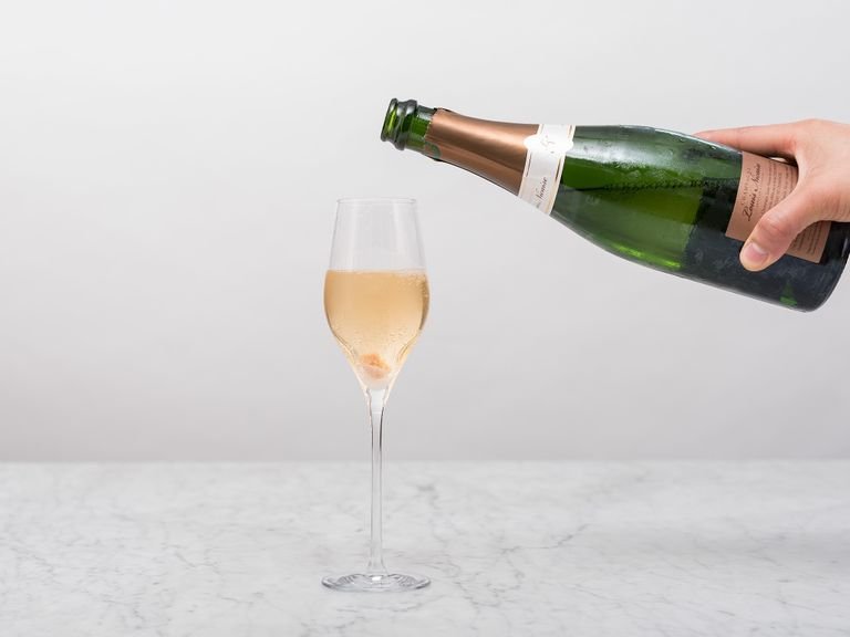 Den Würfelzucker ins Glas legen und mit Champagner aufgießen.
