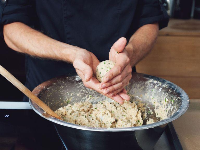 In a large saucepan, bring water to boil and add salt. Turn down heat until the water is hot but does not bubble anymore. Slightly wet hands and form a ball the size of a golf ball out of dumpling dough. Transfer first test dumpling to the saucepan. If it falls apart, add more flour and breadcrumbs to the dough.