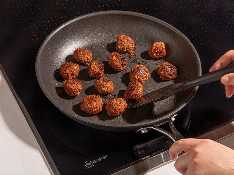 Heat vegetable oil in a frying pan over medium heat. Add vegan meatballs and fry until deeply brown on all sides, approx. 7 min.