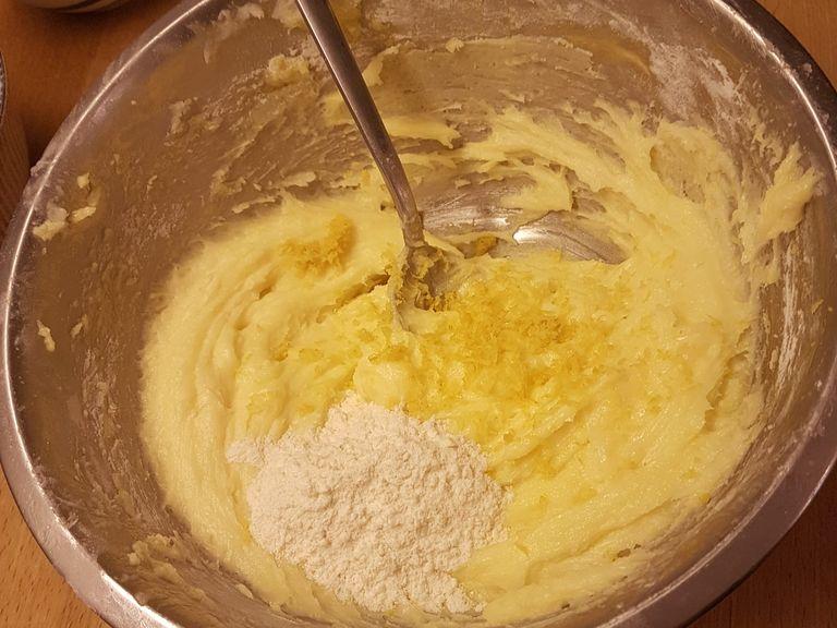 After the starch has been well absorbed, add the grated lemon peel, the baking powder and the spoonful of flour. Mix everything until absorbed