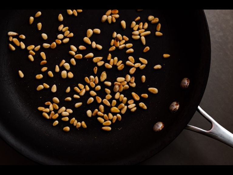 Toast the pine nuts in a pan until golden and fragrant.