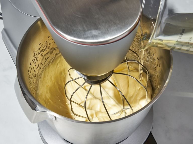 In a medium bowl, whisk the flour, semolina, baking powder, ground spices, and salt to combine and eliminate any lumps. In the bowl of a stand mixer, beat the eggs and the remaining sugar until the mixture is very light, thick, and pale, approx. 5 min. With the mixer still on high speed, gradually stream in the oil and beat until fully incorporated.