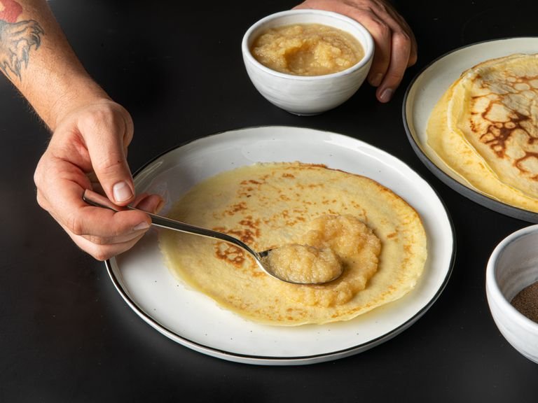 To prevent the pancakes from cooling down, preheat the oven to 50°C/120°F. Place a large ovenproof plate in the middle of the oven and transfer the baked pancakes to the plate one by one, as you cook them. Serve with applesauce and cinnamon and sugar or any other filling of your choice. Enjoy!