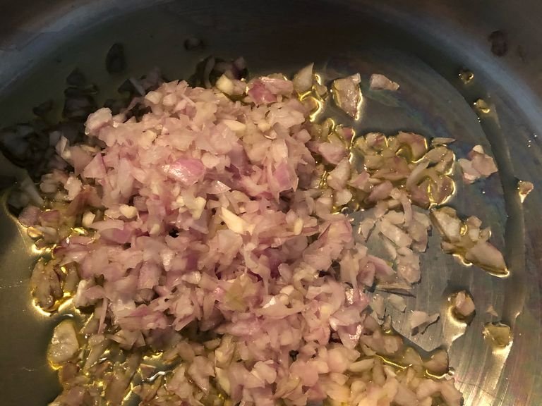 Die Schalotten und den Knoblauch in Olivenöl anschwitzen. Danach den Kohlenkohl und die Kartoffeln hinzufügen und einige Zeit anschwitzen, dabei ab und an umrühren. Nach etwa 5 Minuten mit etwa 2/3 des Weißweins ablöschen und aufkochen lassen. Danach auch die Gemüsebrühe hinzufügen