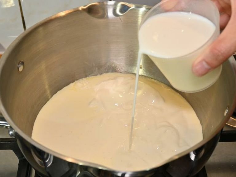 Die Crème double, Milch und Zucker in einem Stieltopf bei mittlerer Hitze zum Köcheln bringen. Dabei ständig rühren, sodass der Zucker sich auflöst.