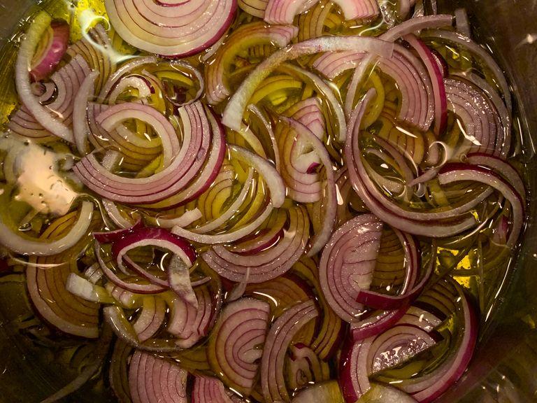 Use a generous amount of extra virgin olive oil, about 1 inch from the bottom of the pot. Set on medium heat. Throw in sliced onions, raise heat to medium high, cover pan and get the onions going. Once they are boiling in the oil lower the heat to medium low.