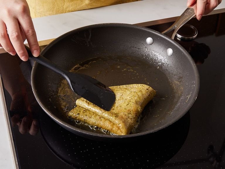 Crack eggs into a bowl, add pesto, whisk well, and season with salt and pepper. Add remaining butter to the pan. Once melted, pour eggs into the pan and let cook for approx. 3 min., or until the bottom of the omelette is set, then fold in half. Let cook for approx. 1 min. more.