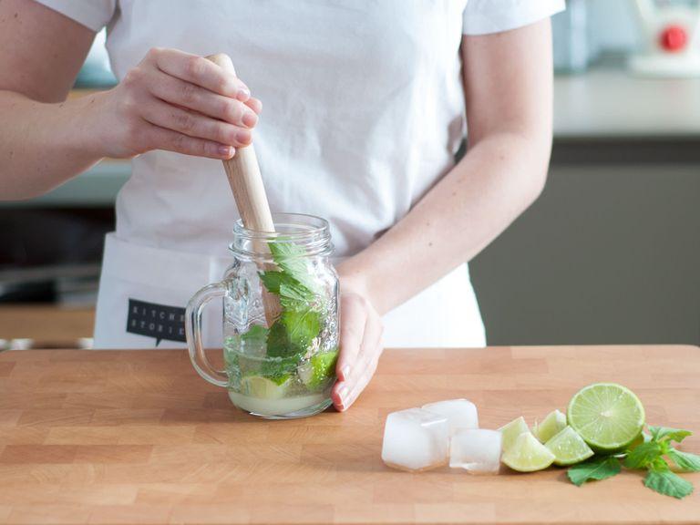 Cut lime into pieces. In a glass, add sugar and lime pieces. Gently muddle mint stalks between the palms of your hand and add to glass. Add soda water and crush ingredients with a pestle.