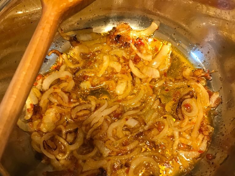 After the onion has golden color, add the red belly pepper and stir again. When the ingredients are mixed move to the next step.