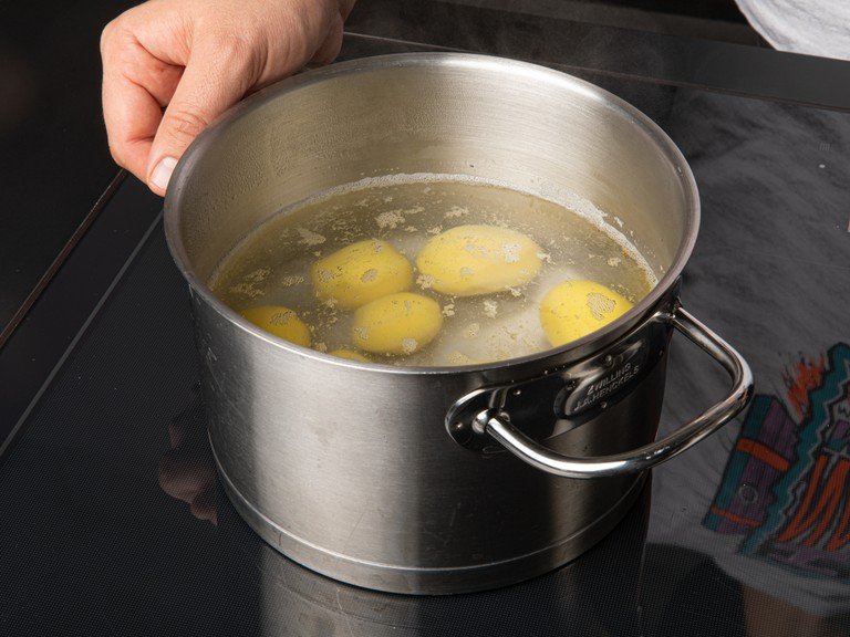 Zwiebeln in Scheiben schneiden. Salbeiblätter abzupfen und die Stiele zum Kochen aufbewahren. Kartoffeln schälen, in einen großen Topf geben und mit Wasser bedecken. Das Wasser gut salzen und bei mittelhoher Hitze zum Kochen bringen. Die Hitze reduzieren und die Kartoffeln ca. 15 Min. kochen, bis sie weich sind. Kartoffeln abgießen und noch kurz im Topf lassen, damit sie etwas ausdampfen können.