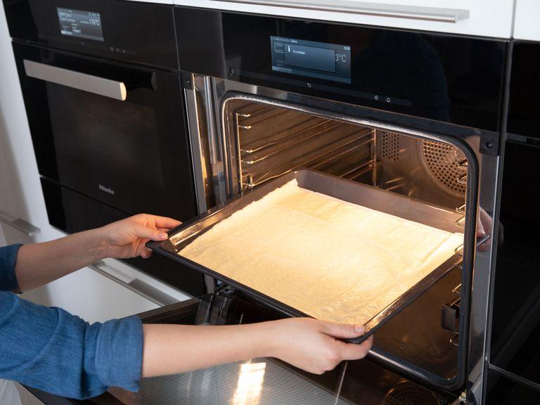 Pizzateig ausrollen und auf das vorbereitete Backblech legen. Im Backofen bei 240°C ca. 10 Min. auf der untersten Schiene ohne Belag backen, bis der Teig leicht gebräunt ist.