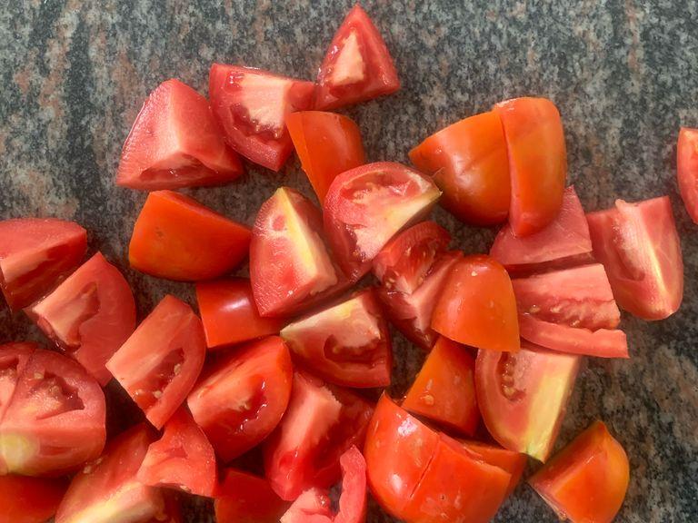 Die Tomaten und Zwiebeln in achtel schneiden.