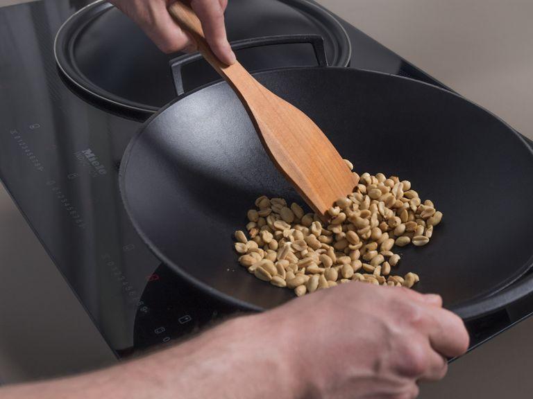 Erdnüsse im Wok auf mittlerer bis hoher Hitze ca. 2 - 3 Min. rösten, oder bis sie goldbraun sind und duften. Aus der Pfanne nehmen und beiseitestellen.