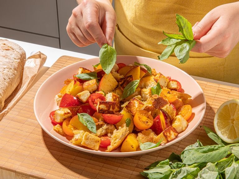 Add crispy bread and halloumi to the tomatoes and nectarines. Mix well; you can even use your hands for this. Season to taste with more salt and pepper and finish with honey, fresh basil, and another drizzle of olive oil. Serve immediately and enjoy!