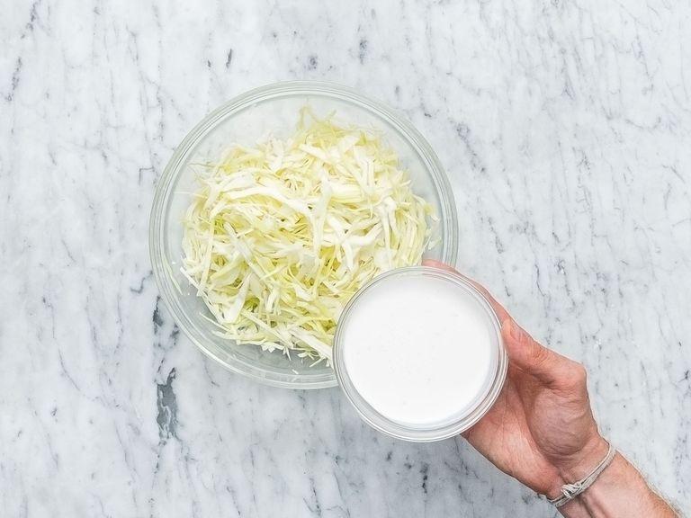 Finely slice white cabbage and transfer to a bowl. Add cashew cream, white balsamic vinegar, coriander, salt, and pepper, and stir to combine. Let sit until serving to marinate.