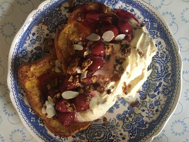 Lay two slices of french toast on a plate, pour a spoon of cream and cherries over and sprinkle the crunch around it. Garnish with mint to make it extra fancy.