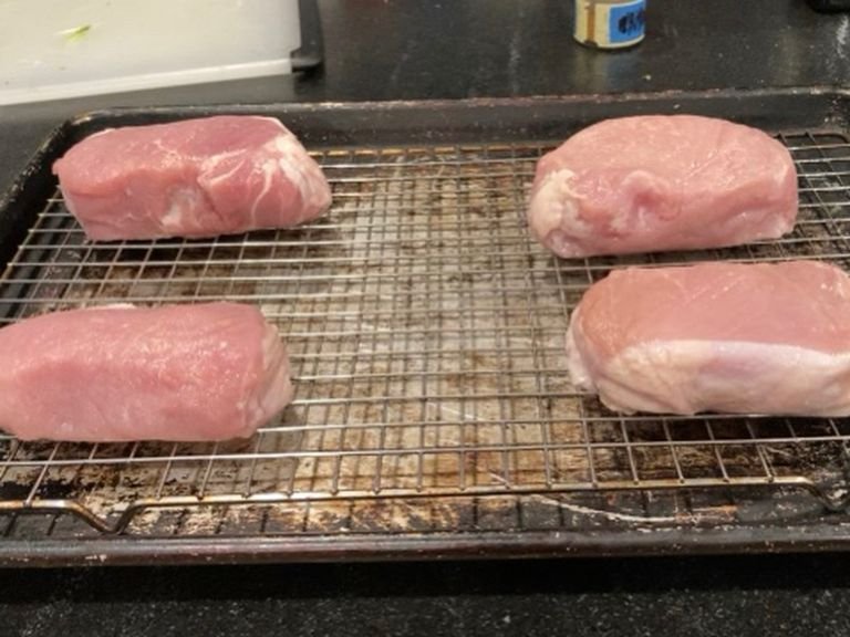 Place a wired rack on a backing sheet and place your pork chops on top, then set aside