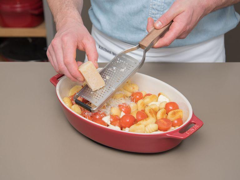 Die angebratenen Gnocchi in die Auflaufform zu den Tomaten geben, Mozzarella in kleine Stücke reißen und ebenfalls hinzufügen. Alles gut verrühren und gleichmäßig in der Form verteilen. Basilikumblätter darauf verteilen und Parmesan darüber reiben. Bei 190°C Oberhitze noch einmal für ca. 10 Min. backen.