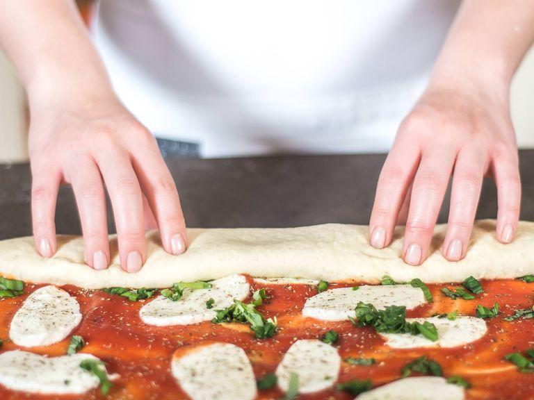 Starting from the long side, roll up the dough from the bottom edge.