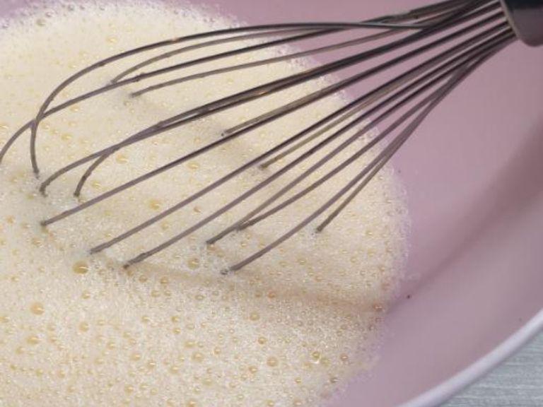 Milch, Zucker und eine Prise Salz in die Schüssel mit dem Eigelb geben und verrühren.