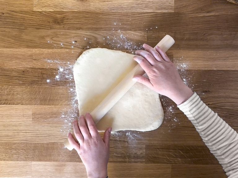 Day 2: Take the dough out of the fridge and turn it onto a lightly floured work surface. Roll it to a. 12x12-in (30x30-cm)  rectangle with a rolling pin. Make sure that the dough is rolled out to an even thickness. Now take the cooled butter out of the fridge, remove the baking paper and place it in the center of the dough at a 45° angle (from your perspective it should be positioned like a diamond).