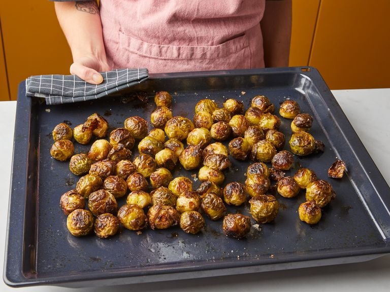 Roast brussels sprouts for approx. 15 min. Carefully shake the baking sheet to move the sprouts around and continue to roast for approx. 10 min. more. Shake baking sheet again, reduce oven temperature to 175°C/350°F, and roast approx. 15 min. more. The Brussels sprouts should be crispy and deeply browned all over, and a paring knife should slide through the center of the sprout easily. If not, roast in 5 min. intervals until tender, then remove from the oven and set aside.