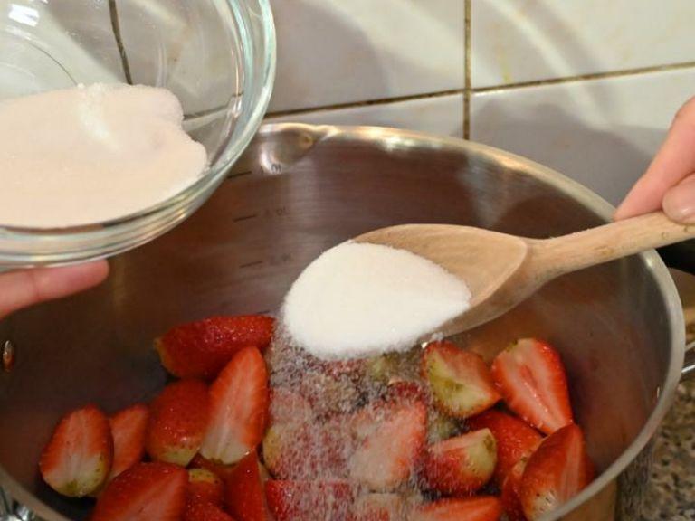 To make the berry coulis: add the strawberries and caster sugar to a saucepan and let it simmer over low heat.