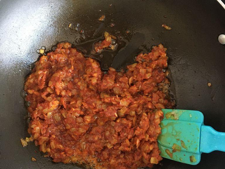 Finely mince garlic and add to the pan, followed by spices (turmeric, cumin, coriander, and chili). Fry until fragrant, then add tomato paste and cook until it has lost its raw taste.