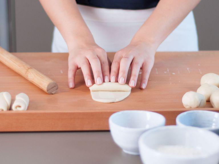 Using a rolling pin, flatten each portion into a thin oblong disc. Roll up each disc with your hands.