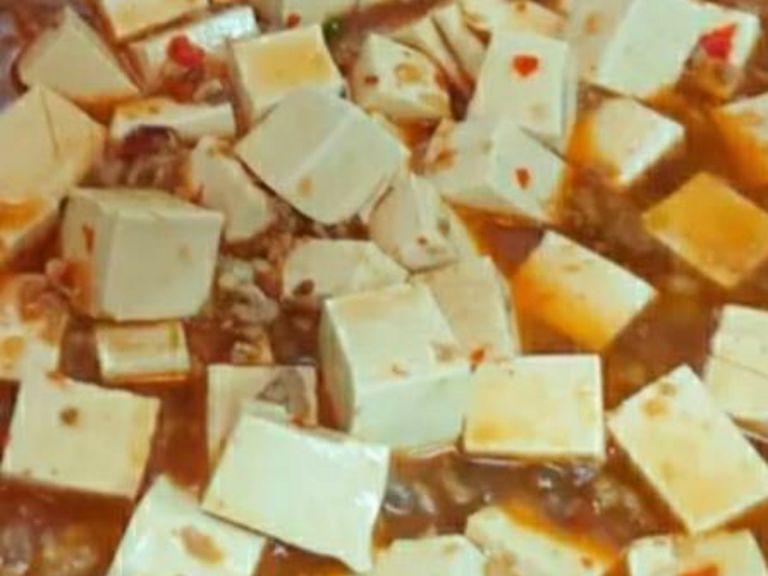 Nun den Tofu in kleine Stücke schneiden. In den Topf geben und abgedeckt für etwa 2 Min. kochen lassen. Speisestärke und gemahlenen Pfeffer hinzugeben. Zum Servieren mit gehacktem Schnittlauch bestreuen und mit Chiliöl beträufeln. Guten Appetit!