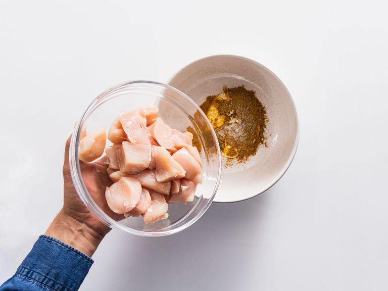 Peel and finely chop garlic. Cut chicken breasts into bite-sized pieces. Add half of the yogurt, ras el hanout, half of the chopped garlic, and some lemon juice to a bowl and stir to combine. Add chicken, season with salt, and toss to coat. Let marinate for approx. 30 min.