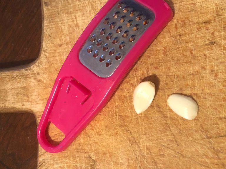 Rub the peeled garlic cloves up and down the grater until the garlic is grated or use knife to finely chop the garlic
