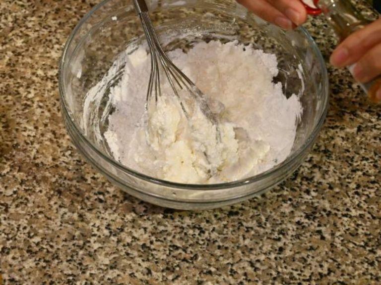 Preparing the icing: add the salt and egg white to the confectioners sugar and whisk together, combining all the ingredients together.