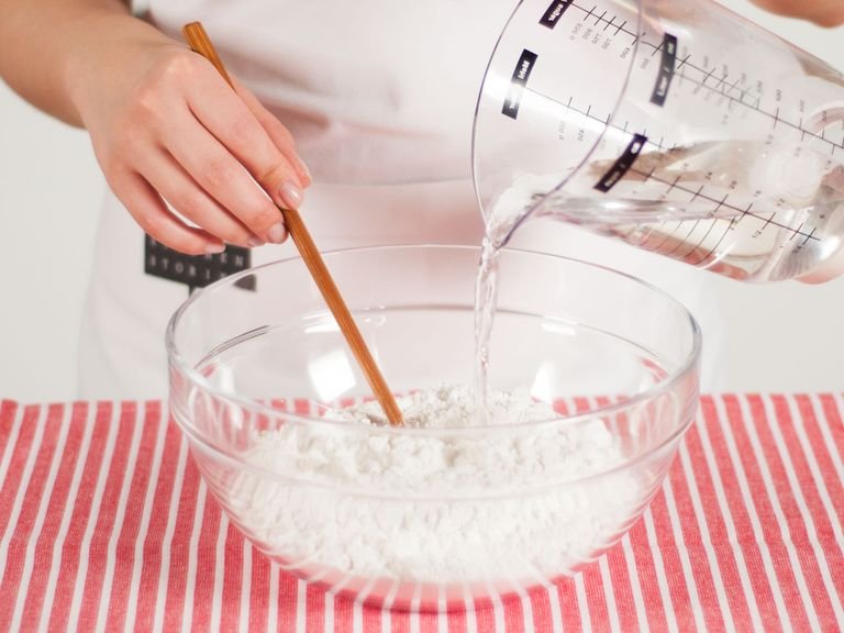 Place the rice flour into a large bowl. First, whisk in the hot water. Then, add the cold water and mix well to combine. Using your hands, form dough into a ball. Cover and set aside.