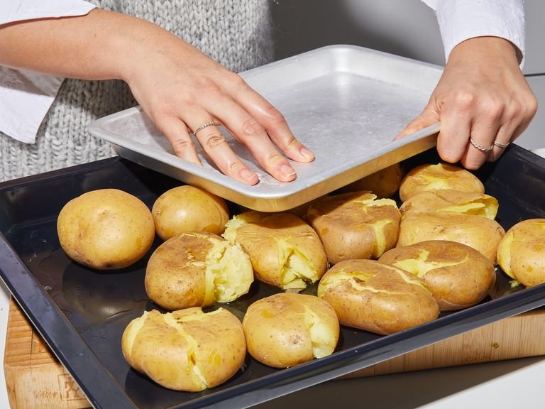 Um die Kartoffeln zu „smashen“, entweder ein weiteres Backblech oder einen Teller auf den Kartoffeln platzieren und zusammenpressen, um die Kartoffeln zu zerdrücken. Großzügig mit Olivenöl beträufeln und mit grobem Meersalz würzen. Das Backblech in den Ofen geben und ca. 30 Min. backen, oder bis die Kartoffeln goldbraun und sehr knusprig ist.